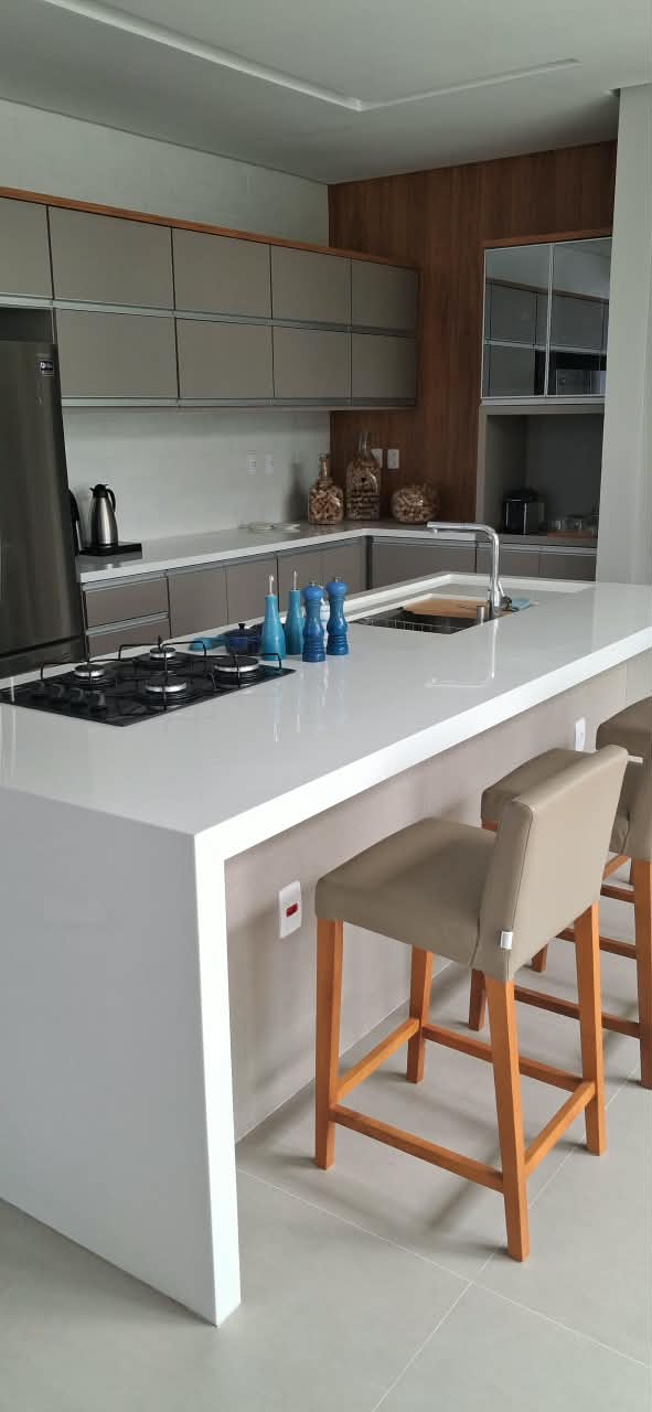 Cozinha com ilha central e armários em tons neutros