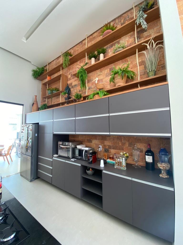 Cozinha com revestimento em tijolos e prateleiras em madeira